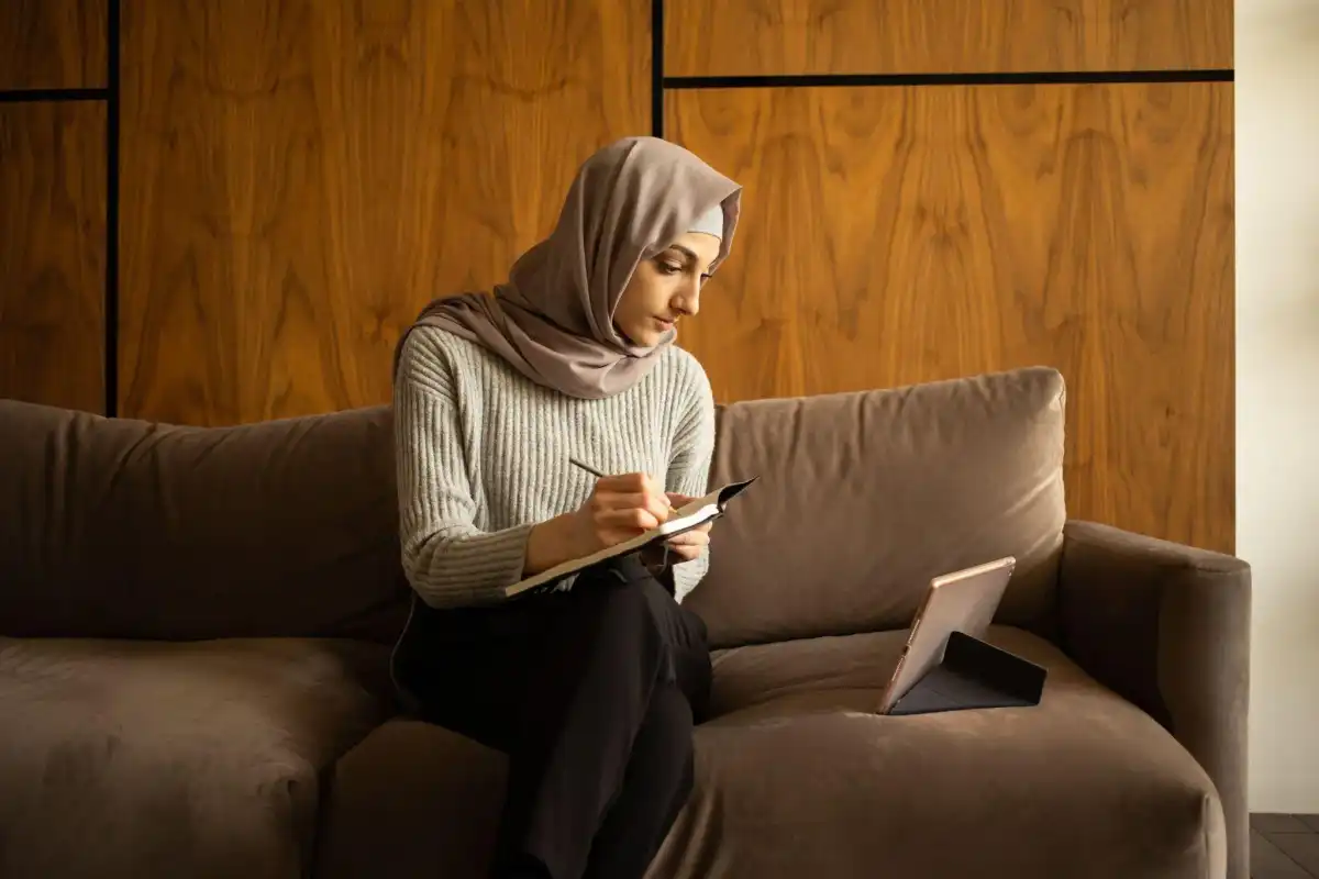 Student in hijab watching lecture videos 